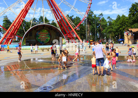 Enfants jouant sur le terrain de jeu avec leurs parents avec des fontaines dans le Parc Gorky à Kharkiv Banque D'Images