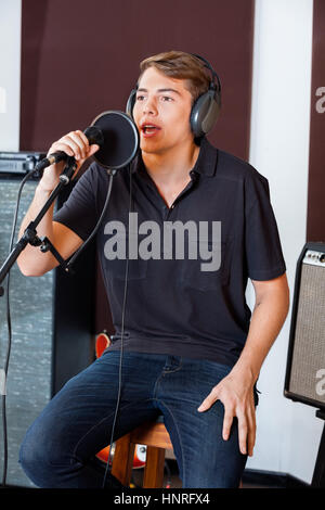 Jeune chanteur d'effectuer en studio Banque D'Images