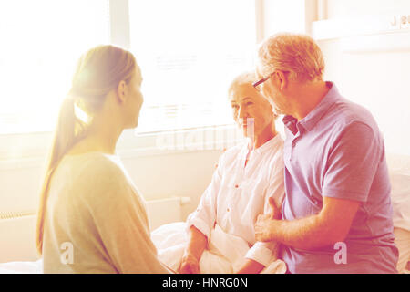 La médecine, soutien familial, aux soins de santé et personnes concept - happy senior couple visiter et encourager sa grand-mère au lit à l'hosp Banque D'Images