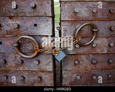 Mighty vieille barrière métallique verrouillée avec une chaîne et un cadenas. Banque D'Images