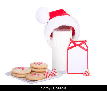 Accueil fait Candy Cane sugar cookies menthe dénudée sur une plaque carrée avec un verre de lait wearing a santa hat avec une carte vierge pour votre moi Banque D'Images