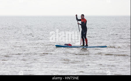 Bournemouth, Dorset, UK. 16 Février, 2017. Météo France : belle journée ensoleillée à la plage de Bournemouth, en tant que visiteurs, chef de la station pour profiter du soleil pour les petites vacances. Paddleboarder bénéficie d'une pagaie. Credit : Carolyn Jenkins/Alamy Live News Banque D'Images