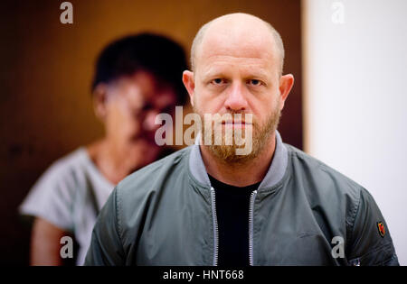 Wolfsburg, Allemagne. 16 Février, 2017. L'artiste sud-africain Pieter Hugo pose devant une photo de Ann Salies (2013) à l'exposition de photos "entre le marteau et l'enclume" au Kunstmuseum (Musée d'art') à Wolfsburg, Allemagne, 16 février 2017. C'est la première exposition solo institutionnel du photographe en Allemagne. Hugo se concentre sur les moyens des gens différents vivent ensemble dans les dictatures. Photo : Julian Stratenschulte/dpa/Alamy Live News Banque D'Images