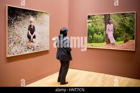 Wolfsburg, Allemagne. 16 Février, 2017. Une femme regarde une photo d'un enfant à l'exposition de photos "entre le marteau et l'enclume" au Kunstmuseum (Musée d'art') à Wolfsburg, Allemagne, 16 février 2017. C'est la première exposition solo institutionnel du photographe en Allemagne. Hugo se concentre sur les moyens des gens différents vivent ensemble dans les dictatures. Photo : Elena Metz/dpa/Alamy Live News Banque D'Images