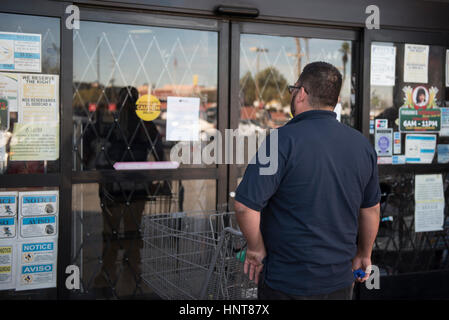 Las Vegas, USA. 16 Février, 2017. Elil Gonzalez lit un signe sur la porte de Mariana's Market indiquant que le magasin est fermé aujourd'hui, grâce à l'une journée sans immigrés protestation. Las Vegas, Nevada, le 16 février 2017. Les entreprises dans de nombreuses villes à travers le pays sont en train de fermer leurs portes pour aujourd'hui comme une réponse au président Donald Trump's politiques anti-immigration. Crédit : Jason/Ogulnik Alamy Live News Banque D'Images