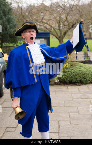 Crier de ville masculine (costume bleu, chapeau tricorne, jabot de dentelle et volants, tenant le rouleau) fait une annonce publique forte - Ilkley, West Yorkshire, Angleterre Royaume-Uni. Banque D'Images