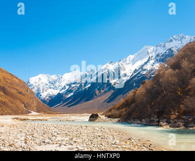 Langtang Valley à haute altitude avec l'eau de la rivière glaciaire menant à de montagnes de l'Himalaya et les Gangchenpo pic en arrière-plan dans Banque D'Images