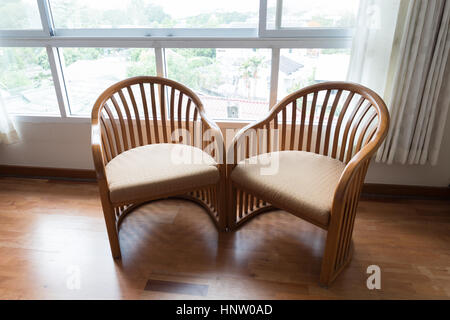 Chaise en bois brun à côté fenêtre dans appartement chambre Banque D'Images