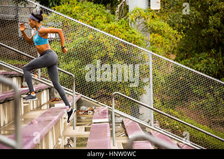 Black woman running on bleachers Banque D'Images