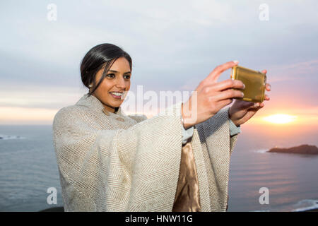 Femme indienne qui pose pour téléphone cellulaire près de ocean selfies Banque D'Images