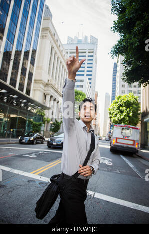 Chinese businessman hailing taxi en ville Banque D'Images