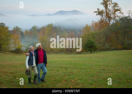 Caucasian couple walking in field Banque D'Images