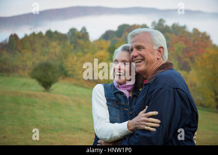 Caucasian couple hugging in field Banque D'Images