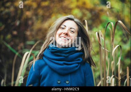 Smiling Caucasian woman wearing blue coat et foulard Banque D'Images