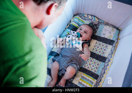 Père regardant bébé dans lit-bébé Banque D'Images