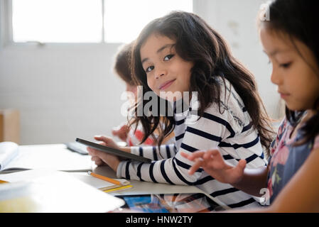 Portrait of smiling girl using digital tablet in classroom Banque D'Images