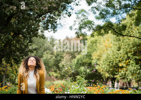 Mixed Race woman relaxing in park Banque D'Images