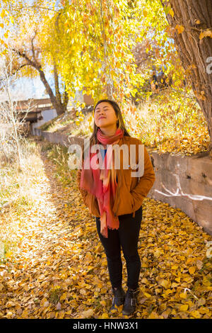 Smiling Asian woman smelling l'air frais à l'automne Banque D'Images