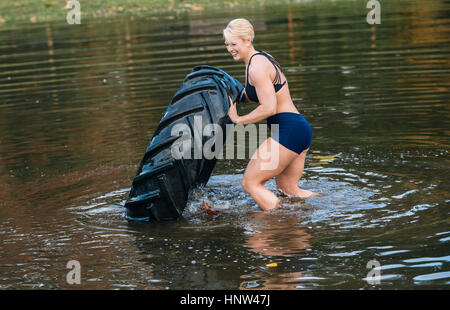 Caucasian woman pneu lourd dans le lac Banque D'Images