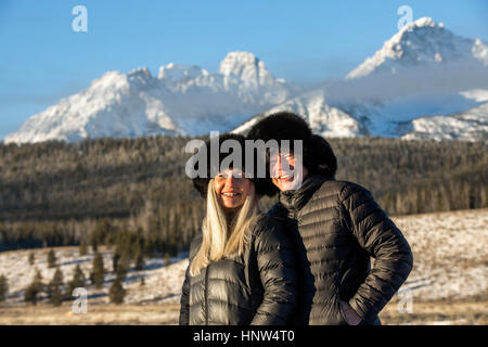 Caucasian couple smiling près des montagnes en hiver Banque D'Images