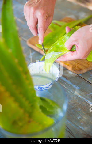 Grattage à la main féminine de feuille d'aloès liquide savon fait à la main en atelier Banque D'Images