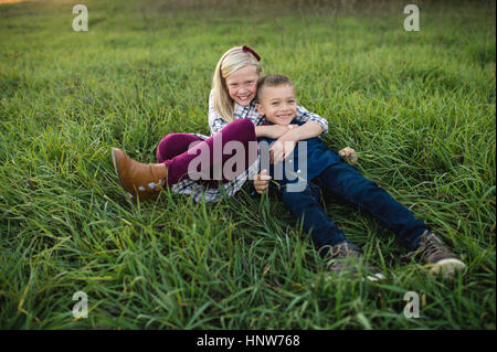 Frère et sœur couchée ensemble sur l'herbe Banque D'Images