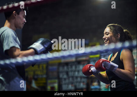 Boxeurs masculins et féminins ayant match de boxe dans l'anneau Banque D'Images