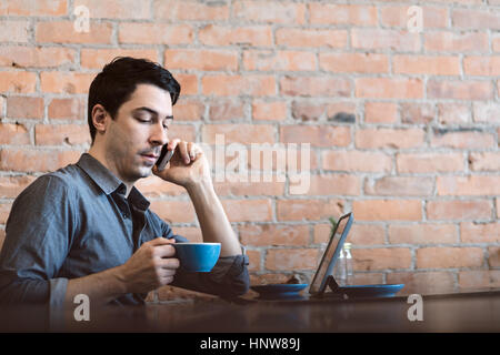 L'homme à l'aide de mobile phone at cafe Banque D'Images