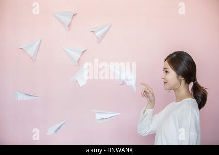 Jeune femme avec des avions en papier blanc Banque D'Images