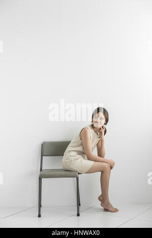 Young smiling woman sitting on chair Banque D'Images