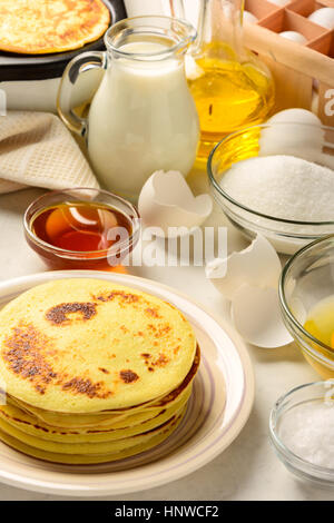 Des crêpes et des ingrédients pour faire des crêpes sur un backgraund blanc Banque D'Images