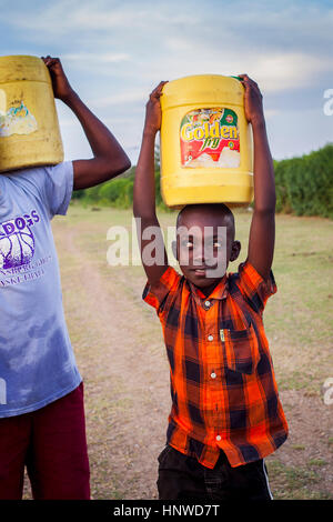 Les enfants portant de l'eau, dans le village de pêcheurs de l'île de Rusinga, Kolunga, Lac Victoria, Kenya Banque D'Images