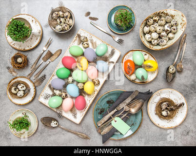 Décoration de table de Pâques avec les oeufs colorés. Arrangement de fête. Mise à plat Banque D'Images