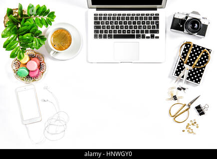 Les fournitures de bureau, ordinateur portable, appareil photo. Café et biscuits macaron. Travail féminin télévision lay Banque D'Images