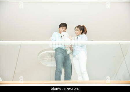 Low angle view of young smiling couple avec Animaux acceptés Banque D'Images