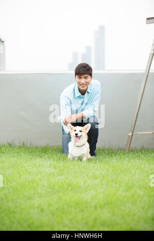 Smiling man with pet dog Banque D'Images