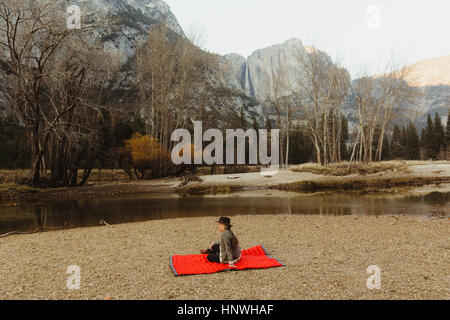 Femme assise sur une couverture rouge en voyant le paysage, Yosemite National Park, California, USA Banque D'Images