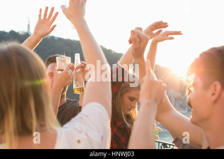 Adult friends dancing au coucher du soleil terrasse sur le toit, Budapest, Hongrie Banque D'Images