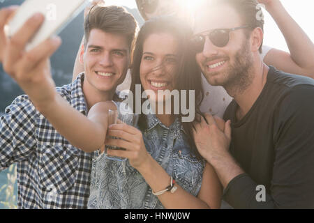 Les amis des jeunes adultes en prenant à parti selfies toit-terrasse Banque D'Images