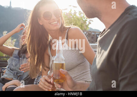 Les jeunes adultes bavarder à toit-terrasse partie Banque D'Images