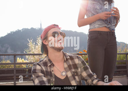 Heureux jeune homme au toit-terrasse ensoleillée partie Banque D'Images