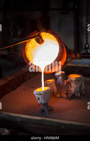 Bronze fondu est versé à partir de la fonderie en pot Banque D'Images