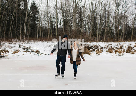 Couple patinage sur lac gelé, Whitby, Ontario, Canada Banque D'Images