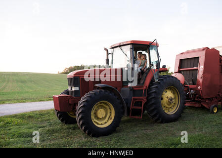 La mère et la fille assis sur le tracteur Banque D'Images