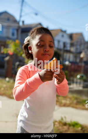 Jeune fille inspecting leaf Banque D'Images