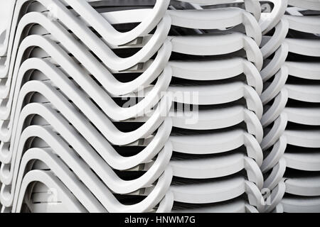 Repliée de chaises en plastique blanc. Pile de chaises longues de plage. Résumé fond ou de texture Banque D'Images