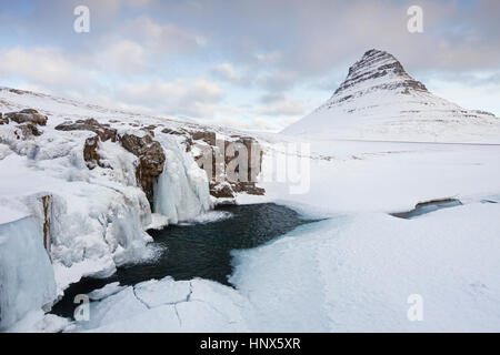 Kirkjufell Mountain et la cascade gelée Kirkjufellsfoss sur la péninsule de Snæfellsnes dans la neige en hiver, l'Islande Banque D'Images