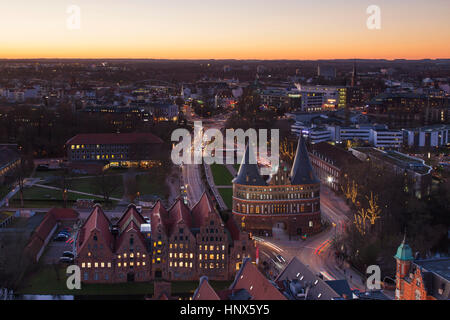 Vue à vol d'oiseau au crépuscule sur la Holsten Gate / Holstein / Tor Holstentor, porte de ville gothique en brique à la ville hanséatique de Lübeck, Schleswig-Holstein, Banque D'Images