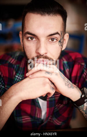 Portrait de tattooed man looking at camera Banque D'Images