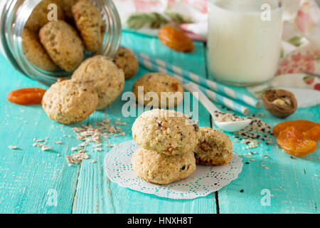 Des aliments sains pour le petit déjeuner. Des biscuits à partir de flocons d'avoine avec des graines de sésame, fruits secs, les noix dans un bocal en verre de lait et on a wooden background Banque D'Images